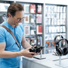homem em loja de acessórios de celular escolhendo o fone de ouvido mais vendido